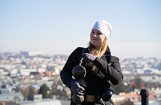 Rauchfangkehrerin am Dach, im Hintergrund Blick auf Wien