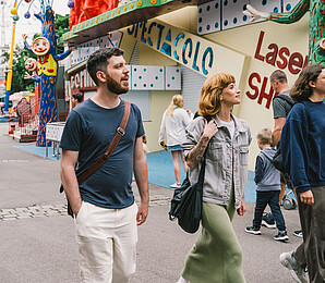 Three young people a man and two women walking into the amusement park Wiener Prater