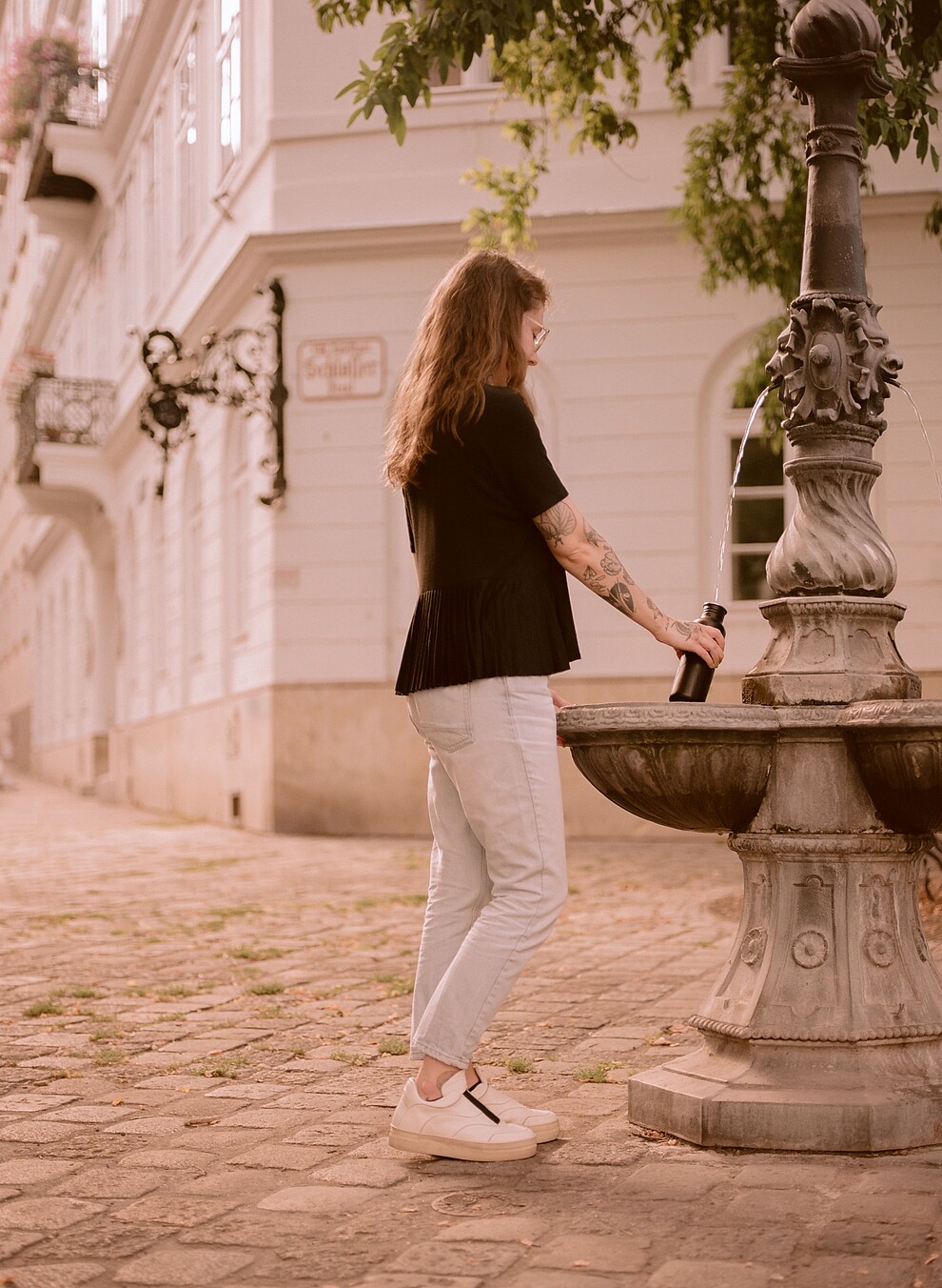 Woman drinking at a water fountain in Vienna