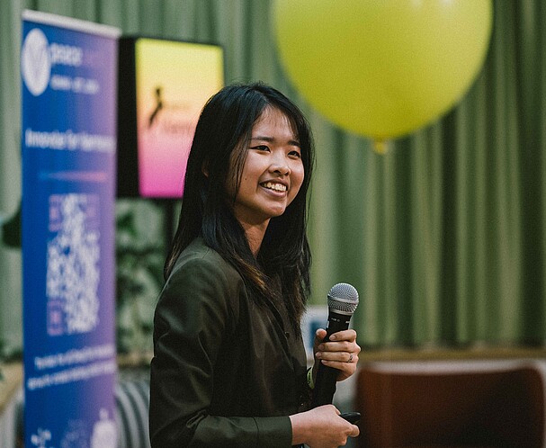 A woman holding a microphone at an event