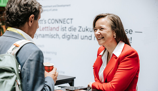 A woman in a red suit jacket smiling at a man