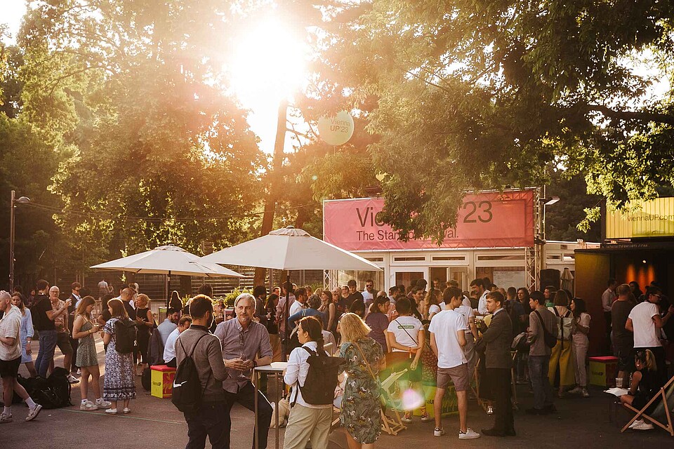 A crowd of people enjoying the afternoon sun at the ViennaUP 2023 Homebase.